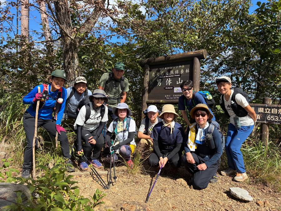 男体山の山頂で記念撮影をするツアー参加者